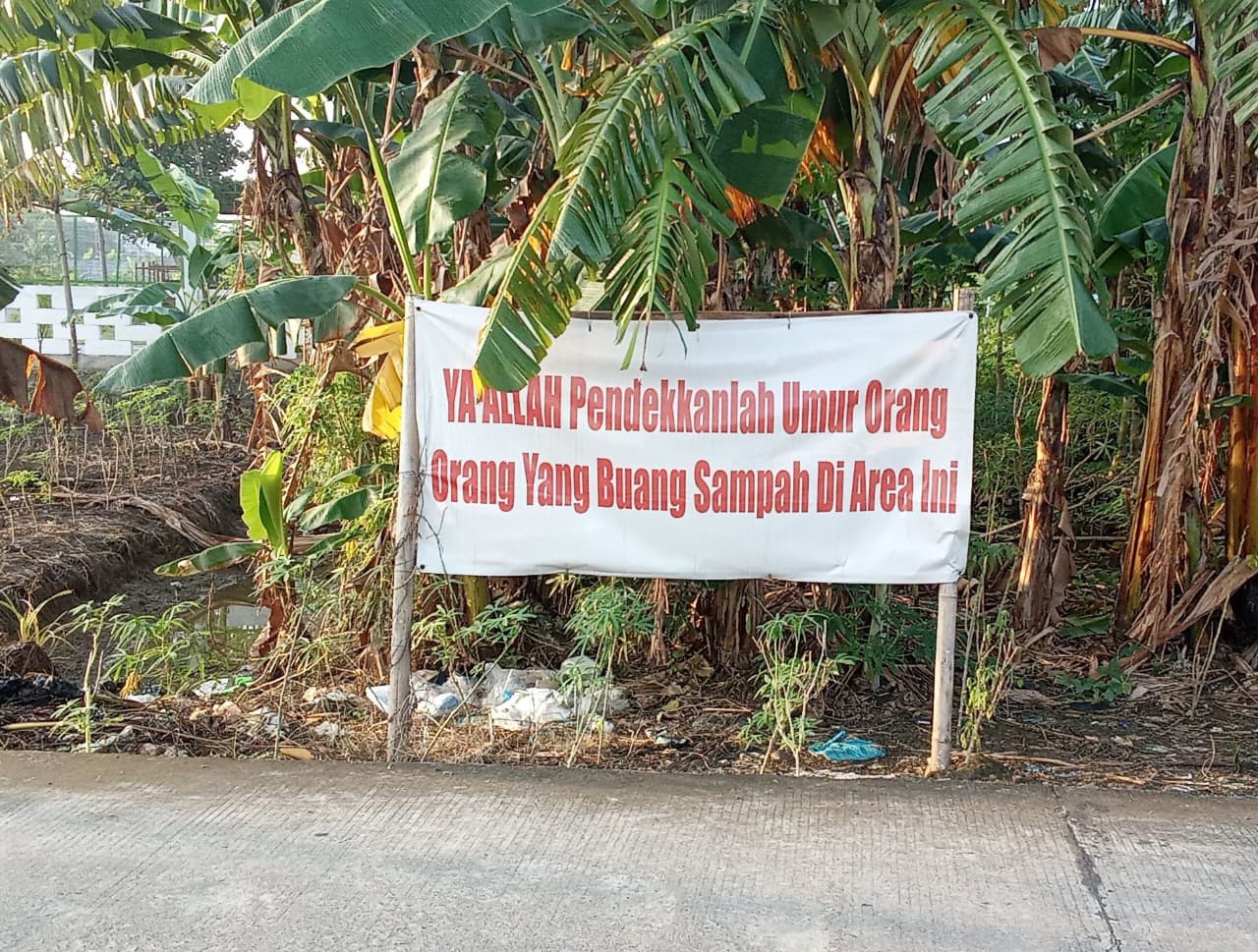 BUKAN LARANGAN BIASA: Spanduk larangan membuang sampah di Jl Tambunan, Kelurahan Tlogosari Wetan, Kota Semarang. (foto: Fikri Bumantara/Javanews.id)